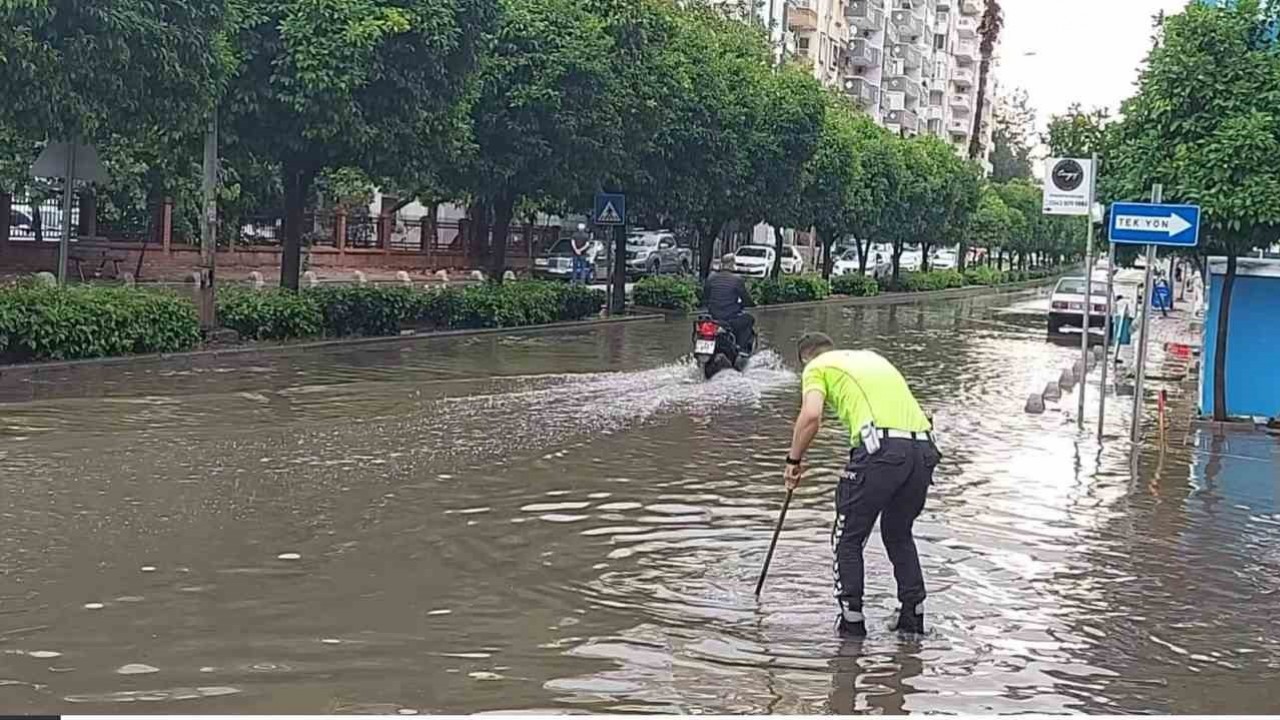 Polisten örnek davranış: Su dolu caddede tıkanan rögarı açtı