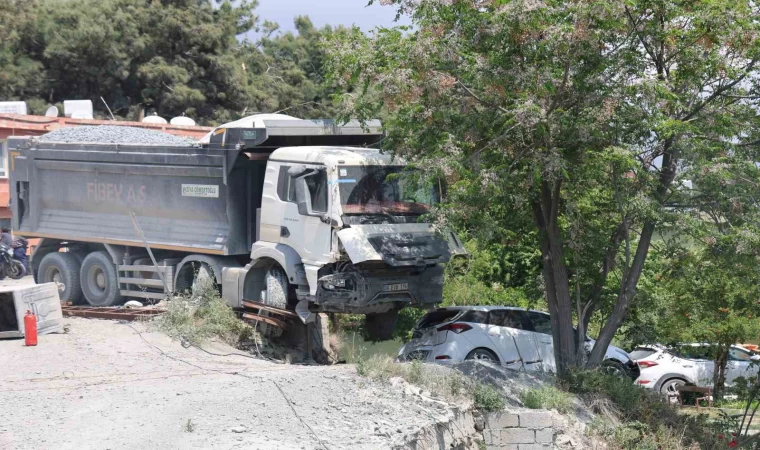 Hafriyat kamyonu otomobilin üzerine devrilmeye ramak kala duvarda asılı kaldı