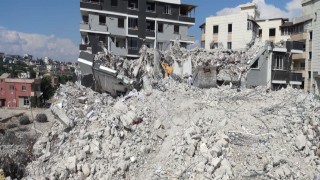 Ağır hasarlı binayı yıkan kepçe operatörü enkaz altında kaldı