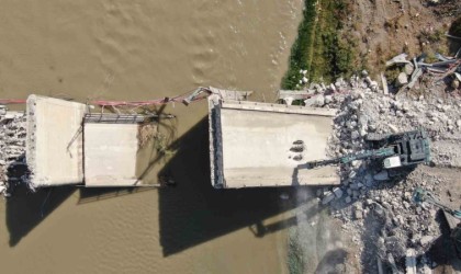 Depremin domino taşı gibi yıktığı köprüyü iş makineleri parçalamakta güçlük çekiyor