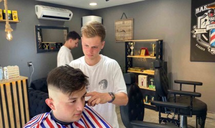 Genç kuaför müşterisini deniz manzarası eşliğinde tıraş etti