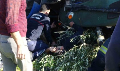 Devrilen traktörün altında kalan sürücüyü itfaiye ekipleri kurtardı