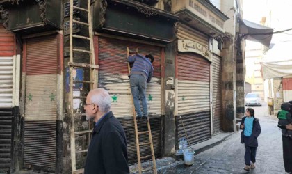 Esnaflar kepenklerindeki eski Suriye bayraklarını kazımaya başladı