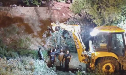 Düştüğü su kanalında çamura saplanan inek, kepçeyle kurtarıldı